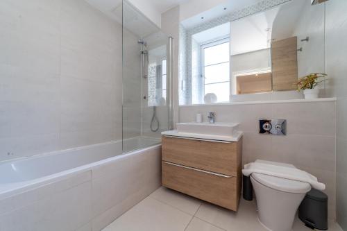 a bathroom with a toilet and a sink and a tub at The Isleworth Collection in London