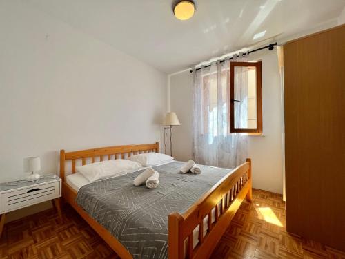 a bedroom with a bed with two pillows on it at Apartmani Bona in Biograd na Moru