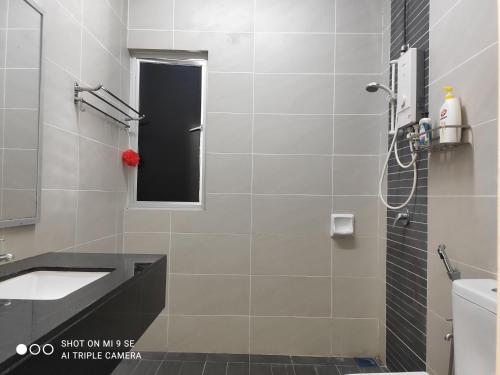 a bathroom with a shower and a sink and a mirror at Pool Smart Tv Wifi 3 aircond room Jitra Kolej Height Utara in Jitra
