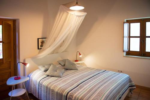 1 dormitorio con 1 cama con dosel blanco en In der Natur und nah am Meer: Casa Sul en Aljezur