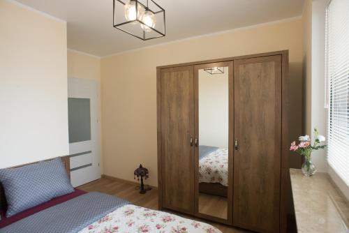 um quarto com uma porta de madeira e uma cama em Mieszkanie Zielony Targówek em Varsóvia