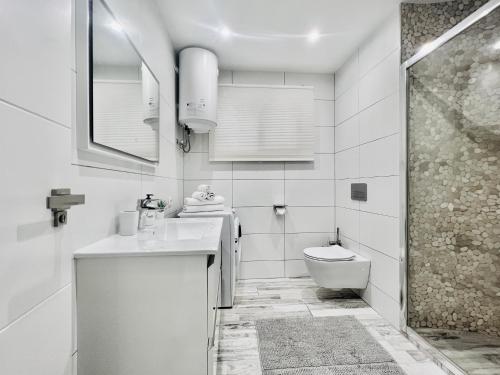 Baño blanco con lavabo y aseo en PaulMarie Apartment Ocean View, en Adeje