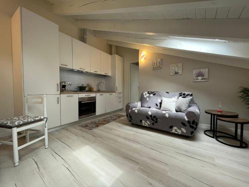 a living room with a chair and a kitchen at Aquadolce in Baveno