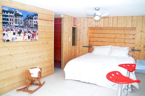 a bedroom with a white bed and a red chair at Maison d'hôtes MIRADOUR in Labenne