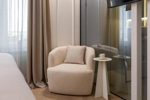 a living room with a chair and a table at Le Prestige Luxury Rooms , Self Check-In, Minutes from Split Waterfront in Split