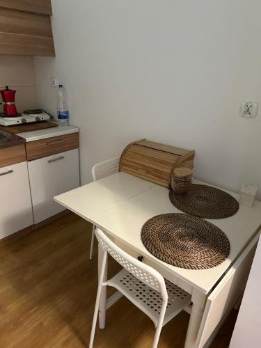 a kitchen with a white table with two chairs at Halszki Flat in Krakow