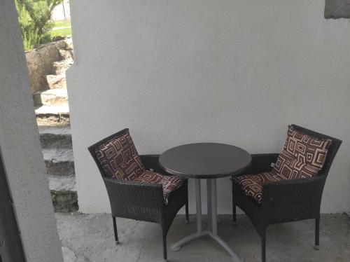 2 Stühle, ein Tisch, ein Tisch und Stühle in der Unterkunft Ajsha Guesthouse in Jajce