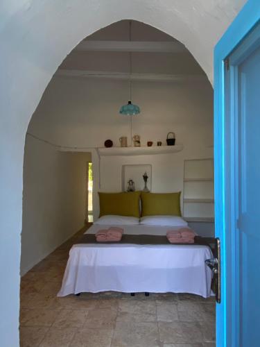 ein Schlafzimmer mit einem großen Bett in einem Torbogen in der Unterkunft Trullo Porta Celeste in San Michele Salentino