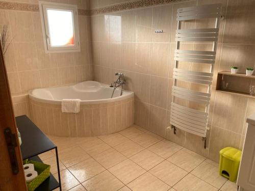 a bathroom with a bath tub and a window at The garden house & aloès bien-être spa in Vierzon