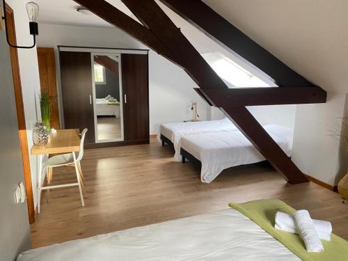 a bedroom with two beds and a table with a chair at The garden house & aloès bien-être spa in Vierzon
