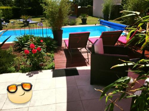 a pool with chairs and a pair of sunglasses at Studio ou maisonnette Sarzeau in Sarzeau