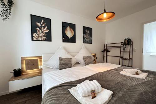 a bedroom with a large bed with two towels on it at AR Apartments III I 4 Pers I Modern I Schillerapartment in Rudolstadt