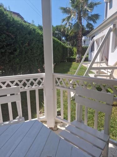 a porch with a white railing and a wooden bench at Villa Pearl Adriatic Coast 2 in Golem