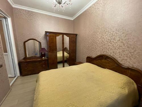 een slaapkamer met een bed, een dressoir en een spiegel bij Veyasum Guest House in Ganja