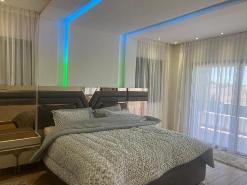 傑迪代的住宿－Villa Nour，一间卧室配有一张带镜子的床和窗户