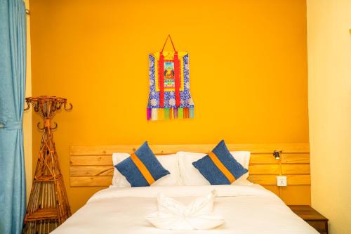 a bedroom with a bed with an orange wall at Kwabahal Boutique Hostel in Kathmandu