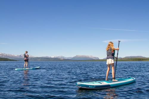 two people standing on paddle boards in the water at Oset Fjellhotell in Gol