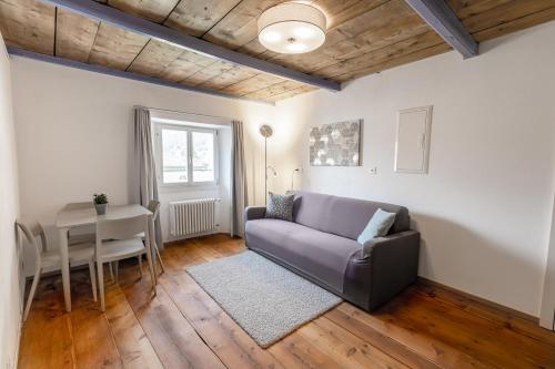 ein Wohnzimmer mit einem Sofa und einem Tisch in der Unterkunft Ca' del Borgo, Rooms & Suites in Poschiavo