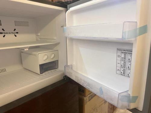 a refrigerator with its door open with a microwave in it at شقة فاخرة في كمبوند ميامى جراند بلازا الإسكندرية in Alexandria