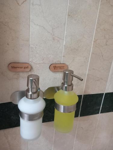 two soap dispensers sitting on a tiled floor in a bathroom at Apto. PIÑA DE MAR in Adeje