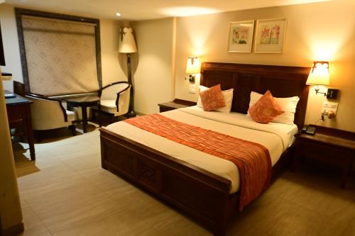 a hotel room with a bed and a desk at Hotel Sai Inn in Mumbai