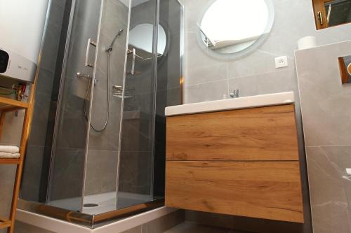 ein Bad mit einer Dusche, einem Waschbecken und einem Spiegel in der Unterkunft Chata Soňa in Terchová