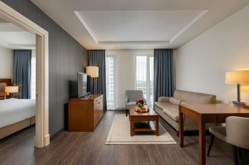 a hotel room with a bed and a living room at Miracle Istanbul Asia Airport Hotel & Spa in Istanbul