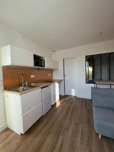 une cuisine avec un évier et un plan de travail dans l'établissement Petite échoppe Bordeaux, à Bègles