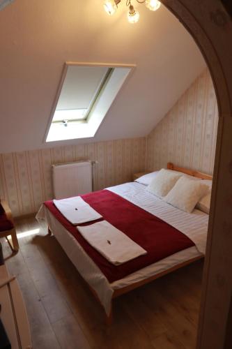 Schlafzimmer mit einem Bett mit einer roten und weißen Decke in der Unterkunft Arany Dió Fogadó in Eger