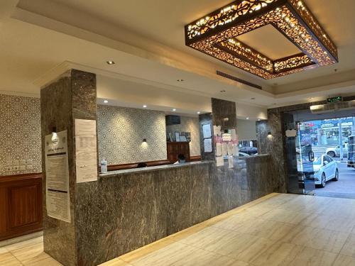 a bar in a restaurant with a chandelier at فندق كنان العزيزية Kinan Al Azizia Hotel Makkah in Makkah