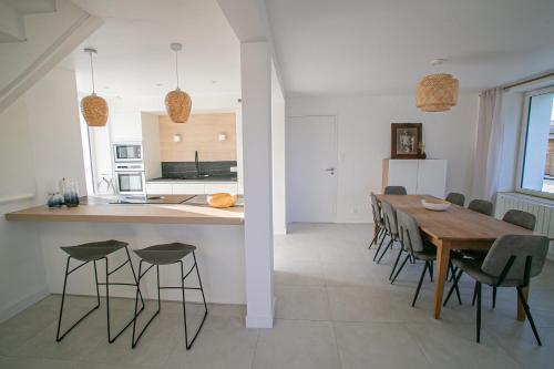 a kitchen and dining room with a table and chairs at Ty Meham, à 700m de la plage et Meneham, grand terrain calme in Kerlouan