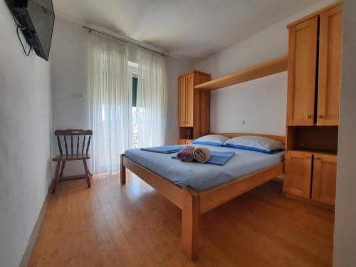 a bedroom with a bed with blue sheets and a chair at San Lorenzo in Lopar