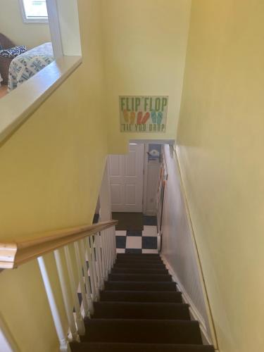 a stairway with a sign that reads flip flop the you must at Sands Townhouses in Old Orchard Beach