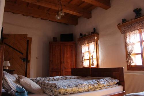 a bedroom with a bed and two windows at Drevenica in Oščadnica