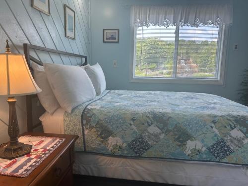 a bedroom with a bed and a window at Sands Townhouses in Old Orchard Beach