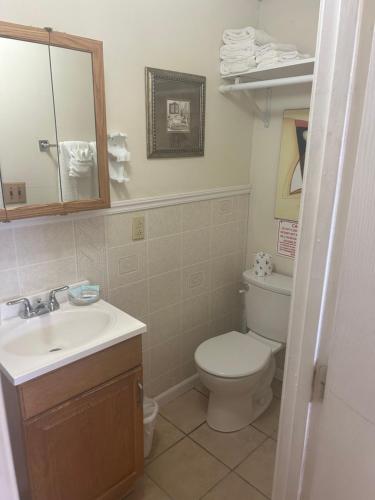 a bathroom with a toilet and a sink and a mirror at Sands Townhouses in Old Orchard Beach