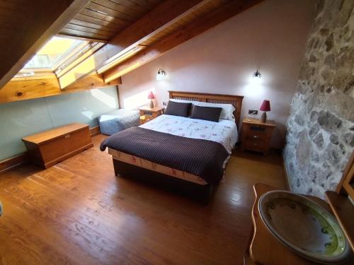 ein Schlafzimmer mit einem großen Bett im Dachgeschoss in der Unterkunft Apartamentos Rias Baixas in Moaña