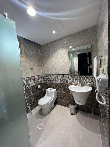 a bathroom with a toilet and a sink at أبراج المصايف للشقق المخدومة in Taif