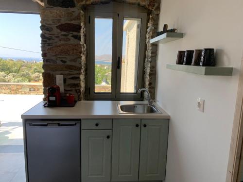 a kitchen with a sink and a window at Karystos Chora Suites in Karistos