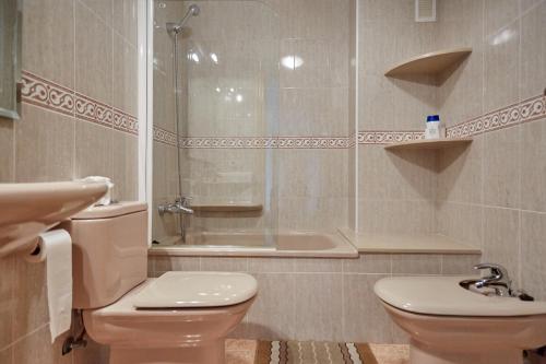 y baño con aseo, lavabo y ducha. en Apartamentos Lorelay 1, en Peñíscola