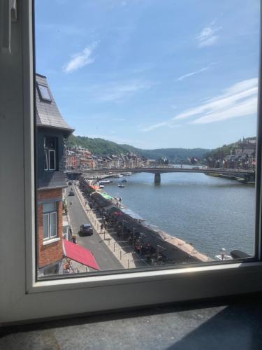 a view of a river and a bridge from a window at Les Terrasses de Sax in Dinant