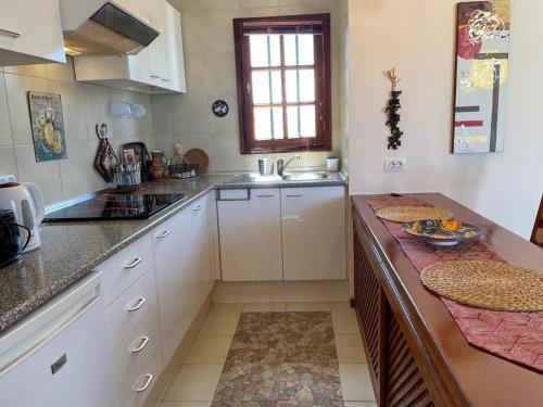 a kitchen with white cabinets and a counter top at The White Dragos with Ocean view in Tías