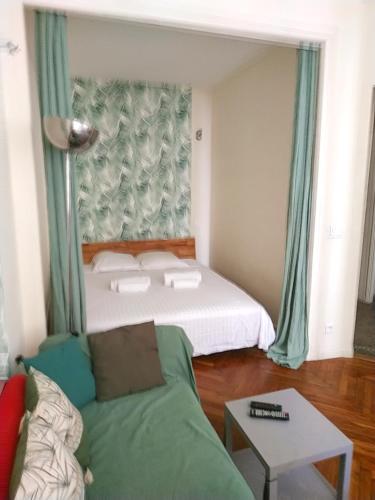 un salon avec un lit et un canapé dans l'établissement Palais Ophelia, à Nice