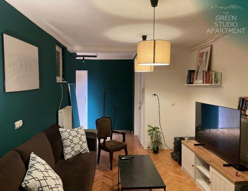 sala de estar con sofá y TV de pantalla plana en Green Studio Apartment en Sarajevo