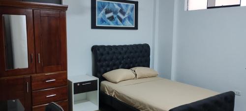 a small bedroom with a bed and a dresser at Makasai Tambopata 3 in Puerto Maldonado