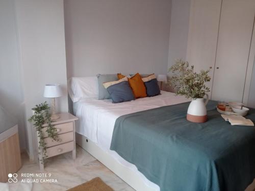 1 dormitorio con 1 cama y 1 mesa con mesita de noche en Nueces y Horkillas Novo Sancti Petri en Chiclana de la Frontera