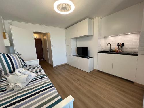 Cette petite chambre comprend un lit et une cuisine. dans l'établissement Joli studio avec une belle vue et Parking Gratuit, à Mauguio