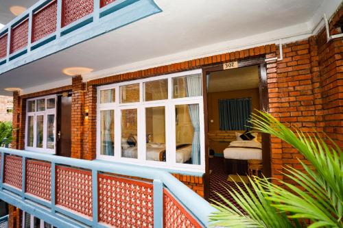 a brick house with a balcony with a bedroom at Kwabahal Boutique Hostel in Kathmandu