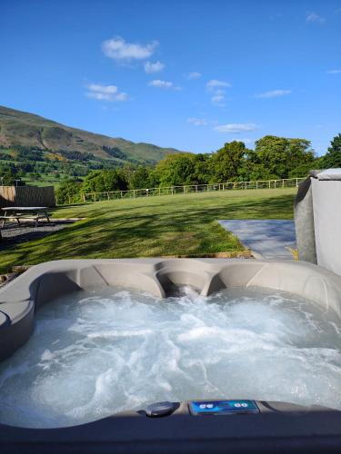 a jacuzzi tub with a view of a golf course at Devonknowes lodges in Tillicoultry