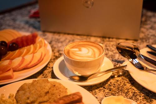 a table with plates of food and a cup of coffee at Kwabahal Boutique Hostel in Kathmandu